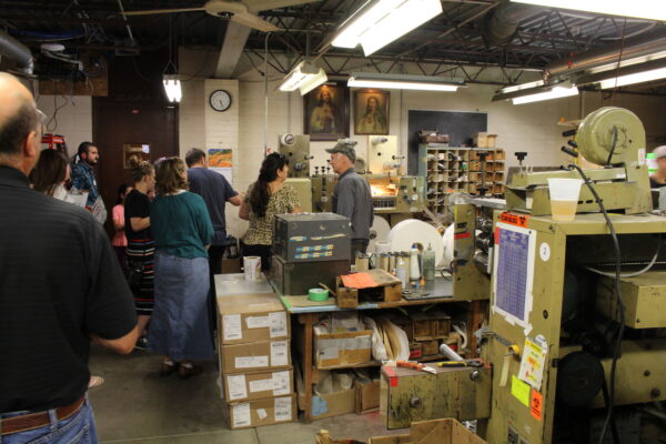 Guests chat with Mike Goldade as he demonstrates the production of some of RPI's items